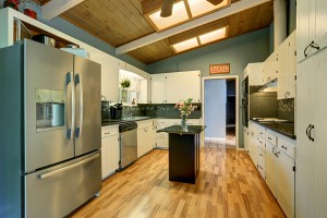 Modernized kitchen with black couter tops and blue interior wall paint.