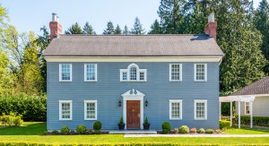 Luxury blue house with beautiful landscaping on a sunny day. Home exterior.